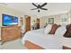 Inviting bedroom featuring a ceiling fan, TV, and an ensuite bathroom at 7591 Harbor View Way, Seminole, FL 33776