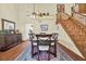 Dining area featuring wood floors, ceiling fan, adjacent staircase, and views of the kitchen at 7591 Harbor View Way, Seminole, FL 33776