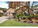 Charming single-Gathering home with brick facade, mature trees, and colorful landscaping in the front yard at 7591 Harbor View Way, Seminole, FL 33776