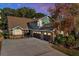 Charming two-story home with a brick exterior and three-car garage at dusk at 7591 Harbor View Way, Seminole, FL 33776