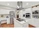 Spacious kitchen with stainless steel appliances, white cabinets, and a large island cooktop at 7591 Harbor View Way, Seminole, FL 33776