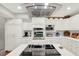 Bright kitchen with white cabinetry, stainless steel appliances, and modern island cooktop at 7591 Harbor View Way, Seminole, FL 33776