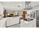 Modern white kitchen with stainless steel appliances and open floor plan to living room with fireplace at 7591 Harbor View Way, Seminole, FL 33776