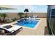 Custom pool with water feature, lounge chairs, and outdoor seating, creating an inviting backyard at 7591 Harbor View Way, Seminole, FL 33776