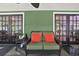 Cozy covered porch seating area with comfortable wicker furniture and double French doors at 7591 Harbor View Way, Seminole, FL 33776