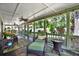 Large screened-in porch featuring comfortable seating and tranquil backyard views at 7591 Harbor View Way, Seminole, FL 33776