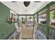 Covered porch offers an inviting outdoor dining space and lush garden view at 7591 Harbor View Way, Seminole, FL 33776