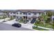 A front exterior view of a neighborhood of townhomes with driveways and sidewalks at 8299 Crescent Oaks Dr, New Port Richey, FL 34655