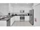 Bright kitchen features white cabinets, granite counters, and stainless steel appliances, with tile flooring at 8299 Crescent Oaks Dr, New Port Richey, FL 34655