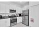 Bright kitchen features white cabinets, granite counters, and stainless steel appliances for easy cooking at 8299 Crescent Oaks Dr, New Port Richey, FL 34655