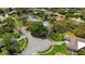 Aerial shot of a suburban neighborhood, showcasing tree-lined streets, well-manicured lawns, and a community pool at 838 Park Ct, Palm Harbor, FL 34683