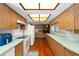 Galley kitchen features plenty of cabinet space, countertops and a garden window at 838 Park Ct, Palm Harbor, FL 34683