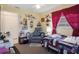Bedroom features chair, bed with patterned bedding, floral decorations, and window with red curtains at 9414 Northcliffe Blvd, Spring Hill, FL 34606