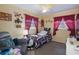 Cozy bedroom with patterned bedding, red curtains, and decorative wall art at 9414 Northcliffe Blvd, Spring Hill, FL 34606