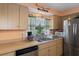 Bright kitchen featuring modern appliances, a double sink with a view, and wooden cabinets at 9414 Northcliffe Blvd, Spring Hill, FL 34606