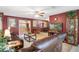 Open concept living room with tile flooring, comfortable leather furniture, and partial views of the dining and kitchen areas at 9414 Northcliffe Blvd, Spring Hill, FL 34606