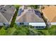 Aerial view of a home featuring solar panels on the roof, with mature trees surrounding the property at 9608 Rolling Cir, San Antonio, FL 33576
