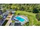 Overhead view showing a pool with chairs and umbrellas and a shuffleboard, illustrating the community's recreational offerings at 9608 Rolling Cir, San Antonio, FL 33576