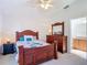 Cozy bedroom featuring a ceiling fan, a wooden dresser, and an ensuite bathroom access at 9608 Rolling Cir, San Antonio, FL 33576