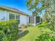 A well maintained home exterior featuring a sunroom and manicured landscaping, set against a clear blue sky at 9608 Rolling Cir, San Antonio, FL 33576