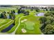 Wide aerial view of a golf course with water features, mature trees, and manicured greens at 9608 Rolling Cir, San Antonio, FL 33576