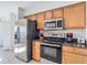 Updated kitchen with stainless steel appliances and light wood cabinetry offers ample storage at 9608 Rolling Cir, San Antonio, FL 33576