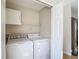 Bright laundry room featuring a washer, dryer, storage cabinet, and wire shelving at 9608 Rolling Cir, San Antonio, FL 33576