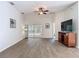 Open-concept living room with wood floors, ceiling fan and access to patio, perfect for entertaining at 9608 Rolling Cir, San Antonio, FL 33576