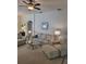Cozy living room with comfortable striped furniture, a ceiling fan, and ample natural light creating a warm ambiance at 9608 Rolling Cir, San Antonio, FL 33576