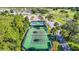 Scenic aerial view of multiple tennis courts surrounded by palm trees and landscaping, showcasing the community's recreational facilities at 9608 Rolling Cir, San Antonio, FL 33576