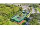 Wide aerial shot showcases pristine tennis courts amidst lush landscaping, highlighting community's commitment to an active lifestyle at 9608 Rolling Cir, San Antonio, FL 33576