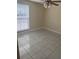 Cozy bedroom featuring tile flooring, a ceiling fan, and a large window for natural light at 10106 Wheatley Hills Ct, Tampa, FL 33615