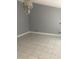 Bright living room featuring tile flooring, neutral walls, and a modern chandelier at 10106 Wheatley Hills Ct, Tampa, FL 33615