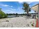 Backyard featuring shell landscaping and large tree on the property with water view and dock at 105 6Th Nw St, Ruskin, FL 33570