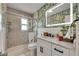 Updated bathroom features a glass shower, unique wallpaper, and a backlit mirror at 105 6Th Nw St, Ruskin, FL 33570