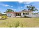 Well-maintained single-story home with a manicured lawn, lush landscaping and a charming white fence at 105 6Th Nw St, Ruskin, FL 33570