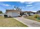 Well-maintained single-story home with a garage, driveway, manicured lawn, and white picket fence at 105 6Th Nw St, Ruskin, FL 33570