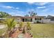Charming single-story home features a tile roof, well-manicured lawn, and lush tropical landscaping at 105 6Th Nw St, Ruskin, FL 33570