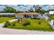 Charming home with green lawn and mature trees, white fence, mailbox, and attached garage at 105 6Th Nw St, Ruskin, FL 33570