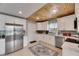 Modern kitchen with stainless steel appliances, white cabinets, and a unique wooden ceiling at 105 6Th Nw St, Ruskin, FL 33570