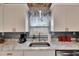 Close-up of a kitchen sink area with marble countertops, stylish lighting, and modern fixtures at 105 6Th Nw St, Ruskin, FL 33570