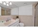 Tiled bathroom featuring a sink, toilet, shower with glass door, and a large mirror at 108 14Th Ave # 2, St Pete Beach, FL 33706