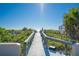 Wooden boardwalk leading to a pristine sandy beach with crystal-clear blue water on a sunny day at 108 14Th Ave # 2, St Pete Beach, FL 33706