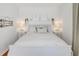 Airy bedroom with a queen-sized bed, two lamps, and simple white decor at 108 14Th Ave # 2, St Pete Beach, FL 33706