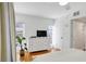 Comfortable bedroom boasts hardwood floors, a dresser with TV, and windows that bring in natural light at 108 14Th Ave # 2, St Pete Beach, FL 33706