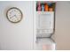 Convenient laundry area with stacked washer and dryer, complemented by a stylish wall clock at 108 14Th Ave # 2, St Pete Beach, FL 33706