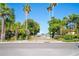 Tropical streetscape with a glimpse of the water through lush, mature palm trees and foliage at 108 14Th Ave # 2, St Pete Beach, FL 33706