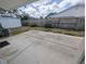 View of the backyard with concrete patio, wooden fence, storage shed, trees, and partial home view on a sunny day at 10968 105Th Ave, Largo, FL 33778
