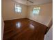 This bedroom has hardwood floors, two windows, neutral walls, and bright natural light at 10968 105Th Ave, Largo, FL 33778