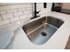 Close up on the kitchen sink with white counters, tile backsplash, and dark fixtures at 11 Lafayette St, Bradenton, FL 34208